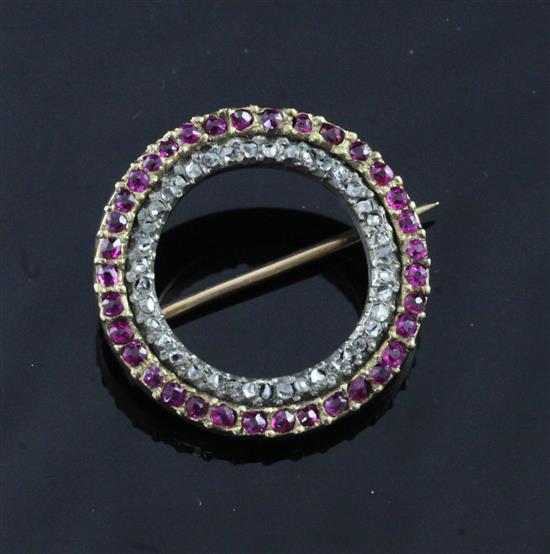 A mid 20th century gold, ruby and diamond set open circle brooch, 23mm.